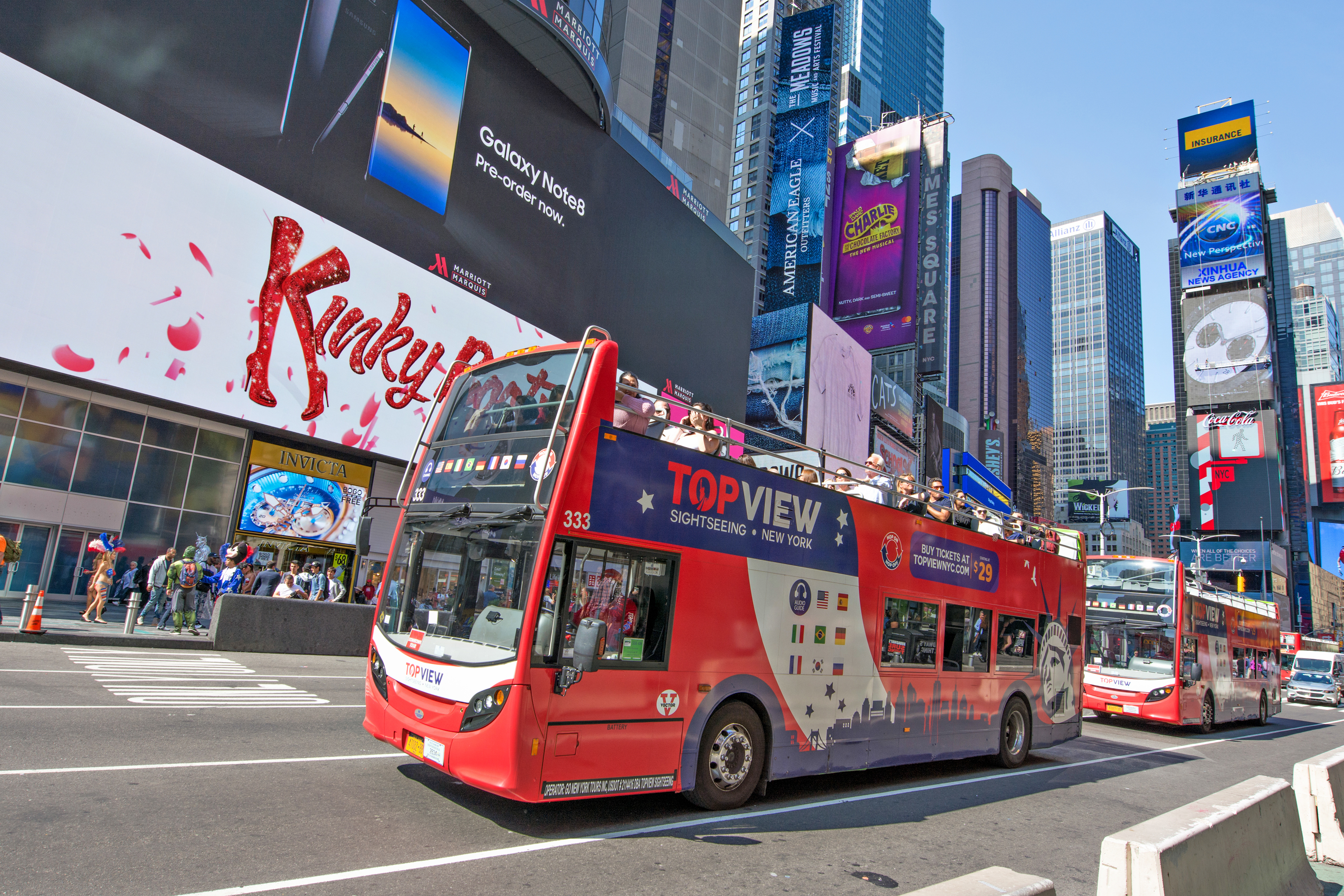 A touring bus driving through the middle of Times Square in New York City.
