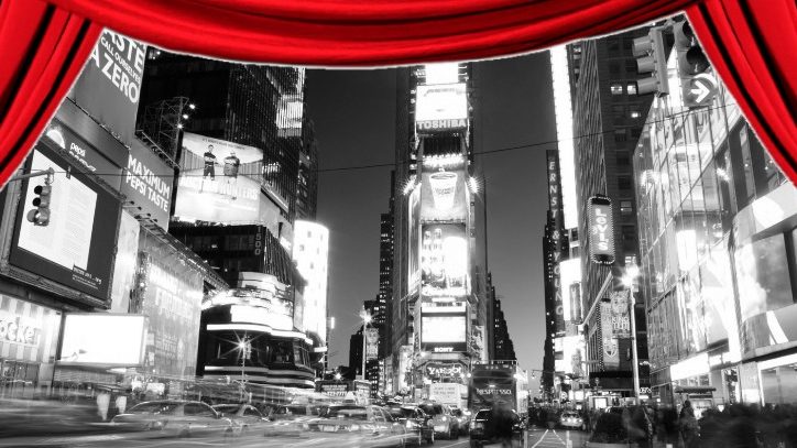 A red curtain revealing Times Square in black and white