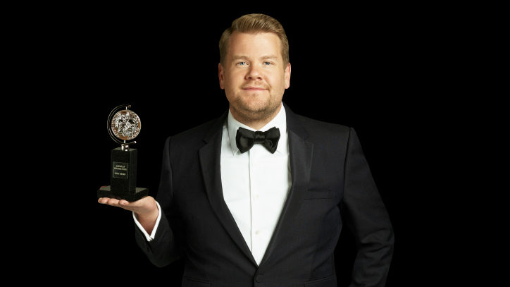 James Corden holding a Tony Award in a black Tuxedo for the Tony Awards