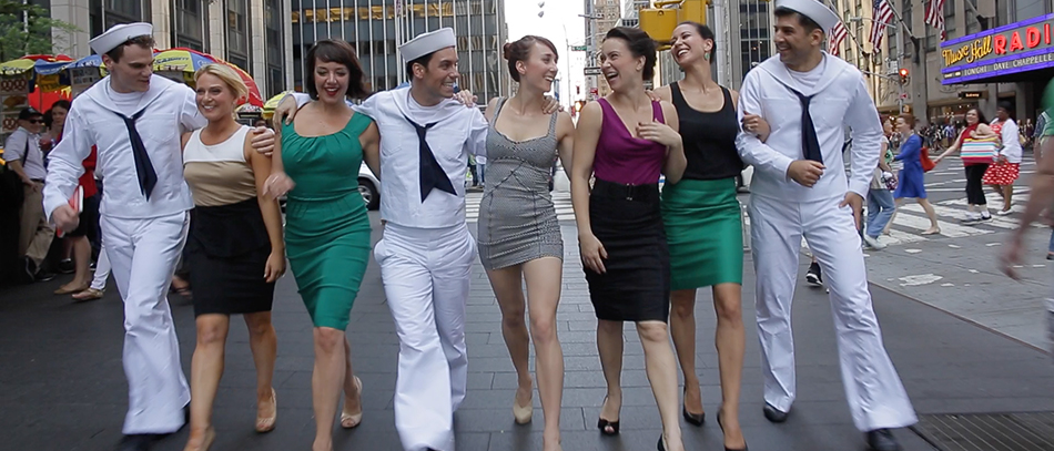 The Broadway cast of On The Town walking through Times Square