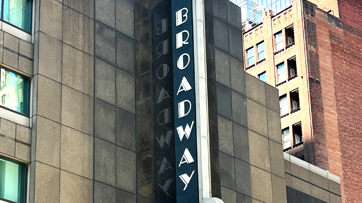 Broadway Theatre writes 'Broadway' in white all-caps vertical lettering on a blue background above the theatre entrance.