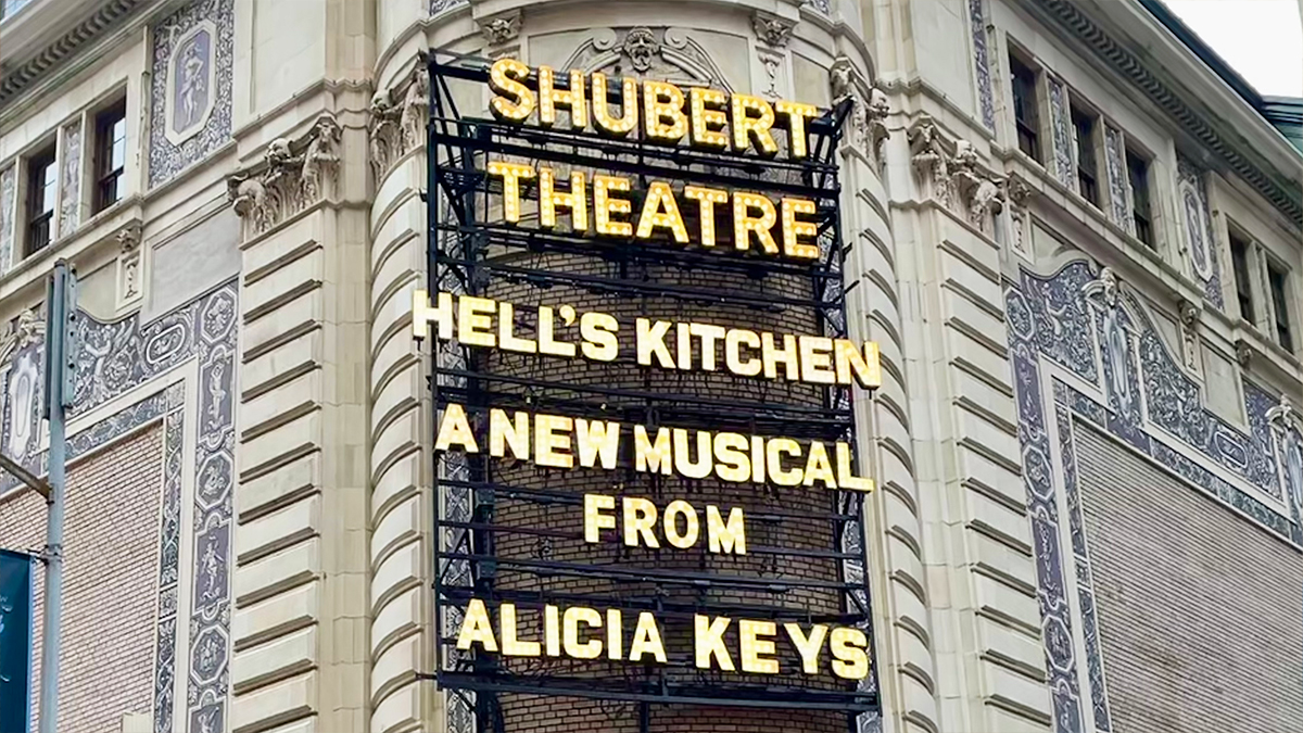 Shubert Theatre marquee displays 'Shubert Theatre' in gold all-caps lights with the current playing show 'Hell's Kitchen: A New Musical From Alicia Keys' in the same gold all-caps lights right below.