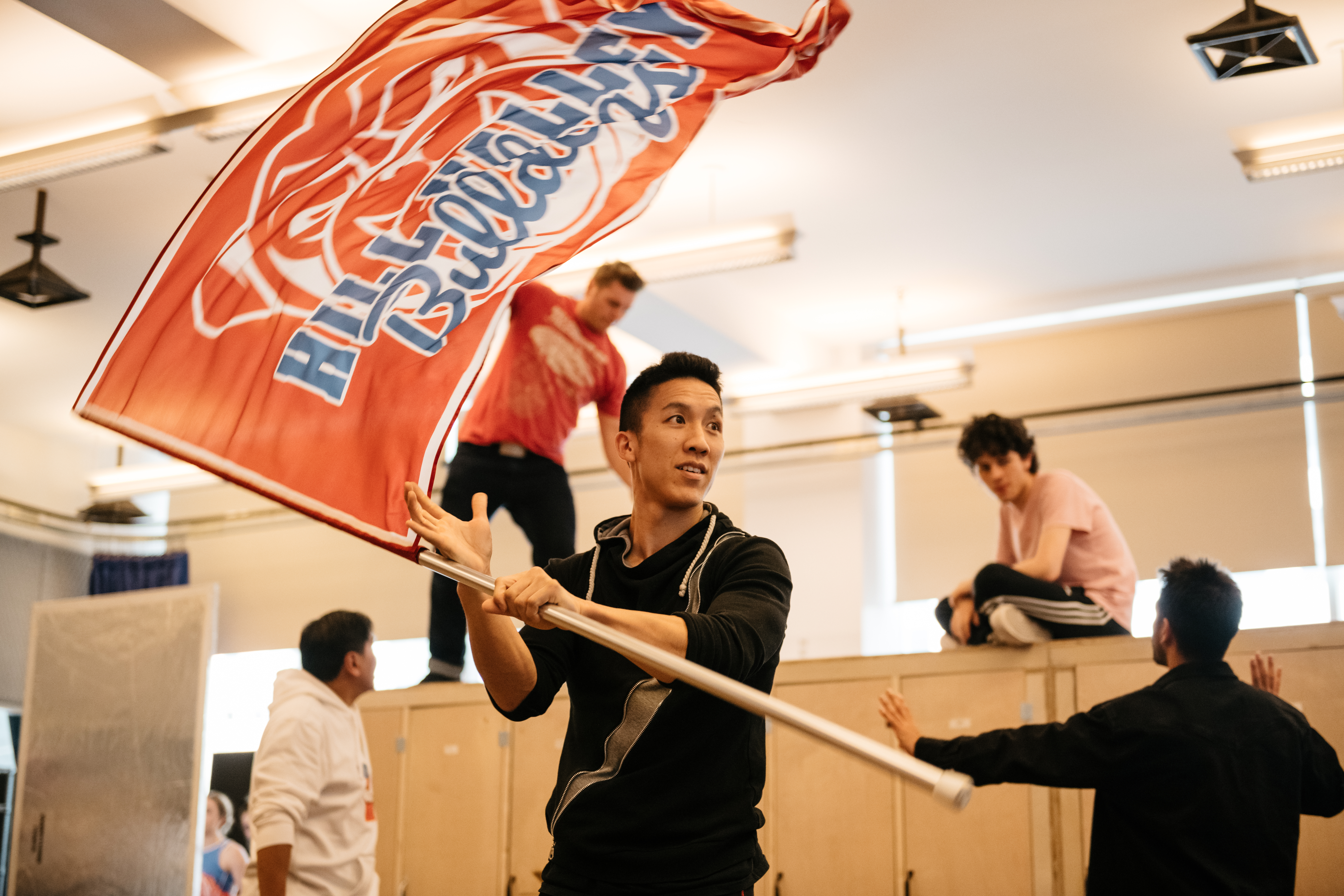 Brendon Chan waving a flag in rehearsal