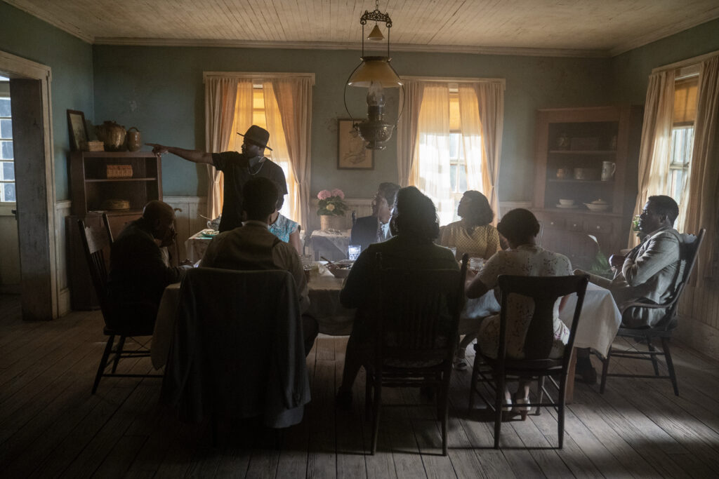 Director Blitz Bazawule (standing) with Louis Gossett Jr., H.E.R., Jon Batiste, Taraji P. Henson, Colman Domingo, Fantasia Barrino, Danielle Brooks and Corey Hawkins on the set of The Color Purple. Photo by Eli Ade.
