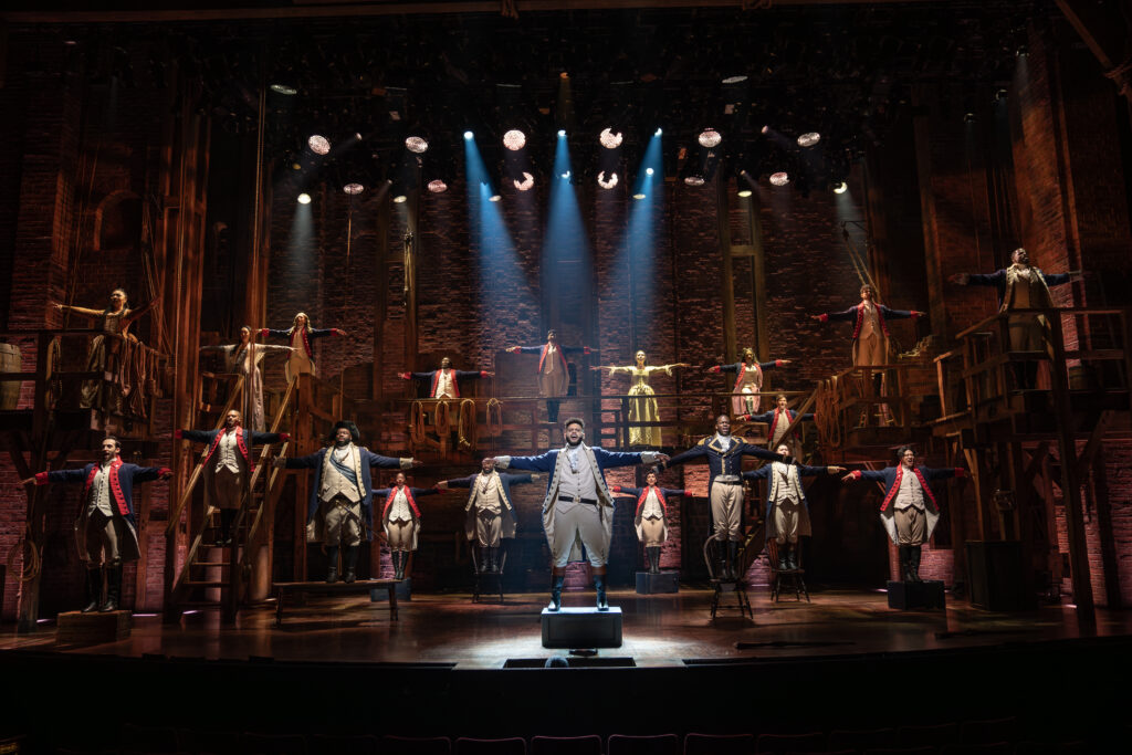 Trey Curtis (center) and the cast of Hamilton. Photo by Joan Marcus.