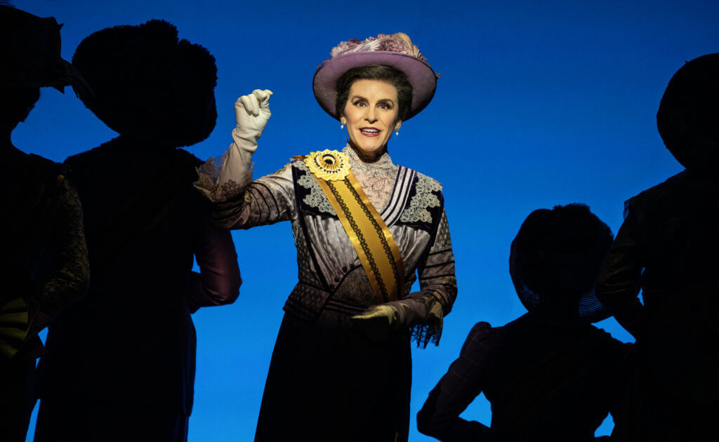 Jenn Colella as Carrie Chapman Catt in Suffs.
