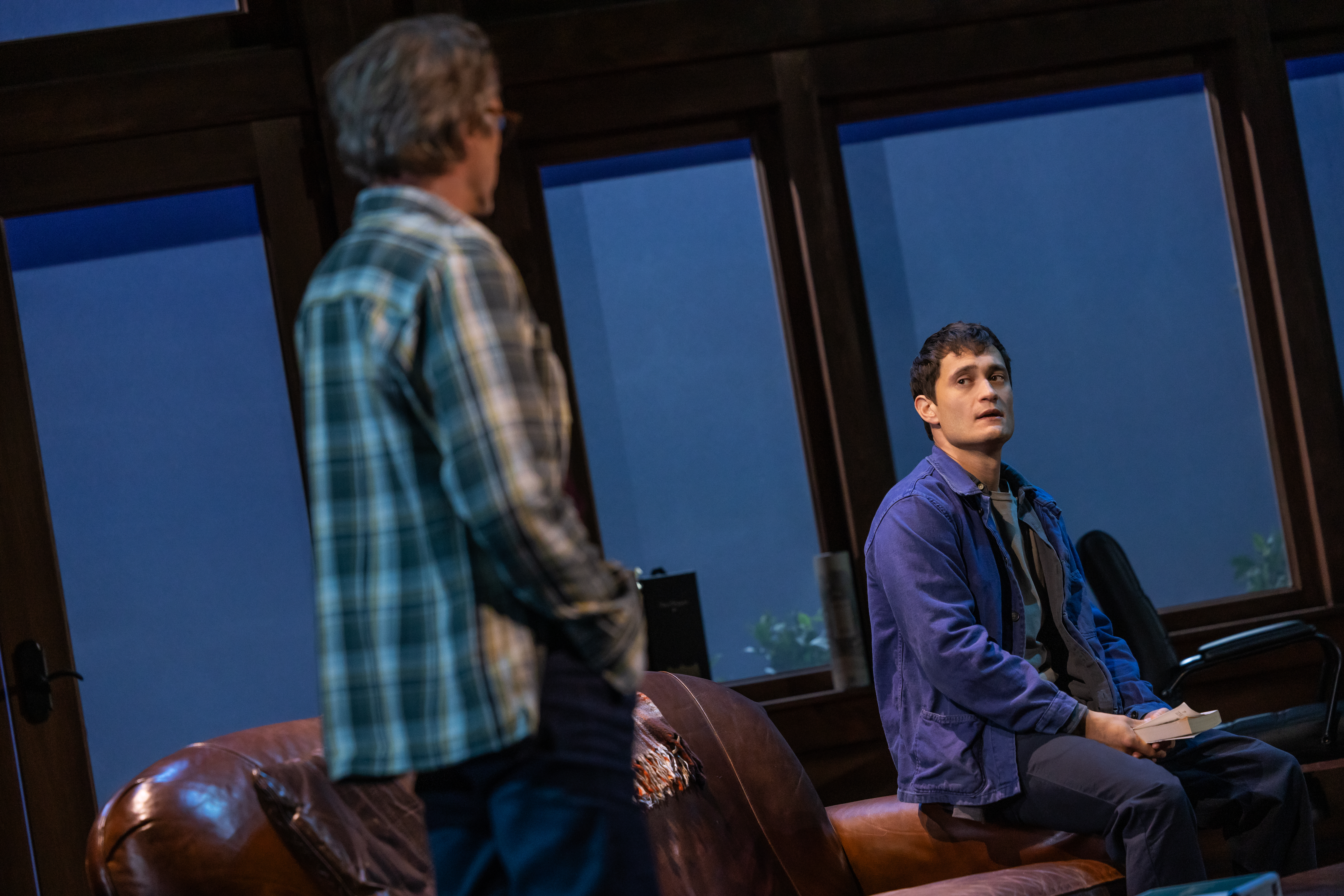 Two characters looking at each other, one character is sitting on a couch