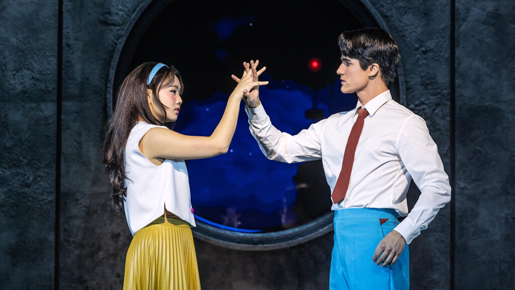 Helen J Shen and Darren Criss grasping hands in Maybe Happy Ending.