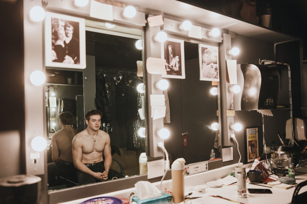 Kit Connor (Romeo) from Romeo + Juliet. Photo by Emilio Madrid. Connor is looking at himself in the mirror in his dressing room