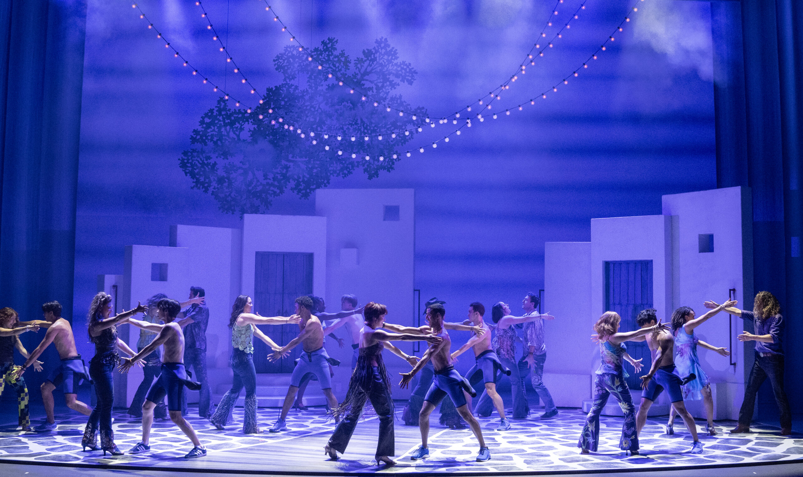 The Company of MAMMA MIA! dancing.
